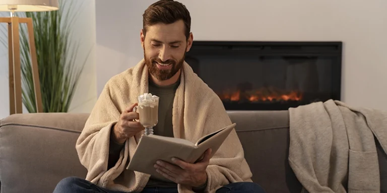 heating faq - common heating problems - man wearing blanket with cup of coffee